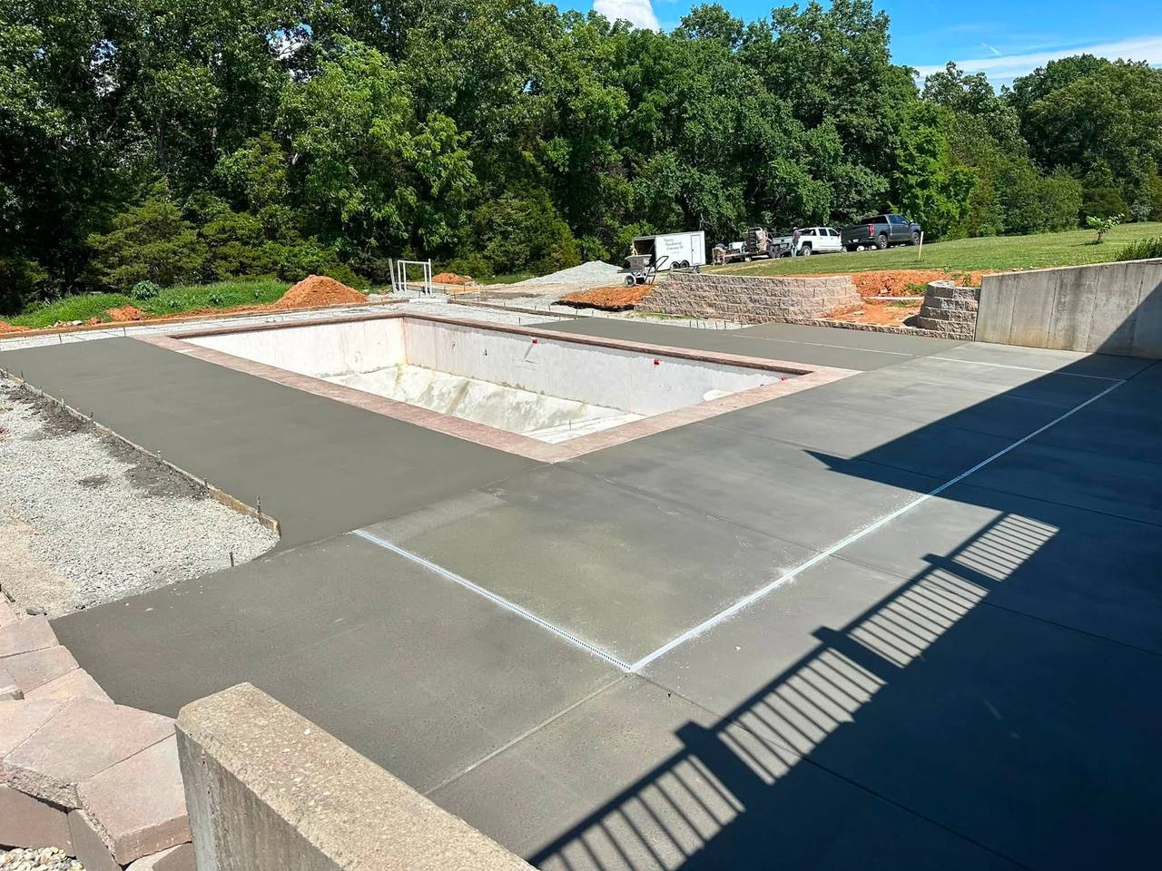 Fresh pool deck pour with the work trailer in the distance